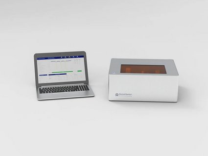 Current compact prototype of the Advanced Quantum Devices system on a desk next to a laptop running the internal measurement software